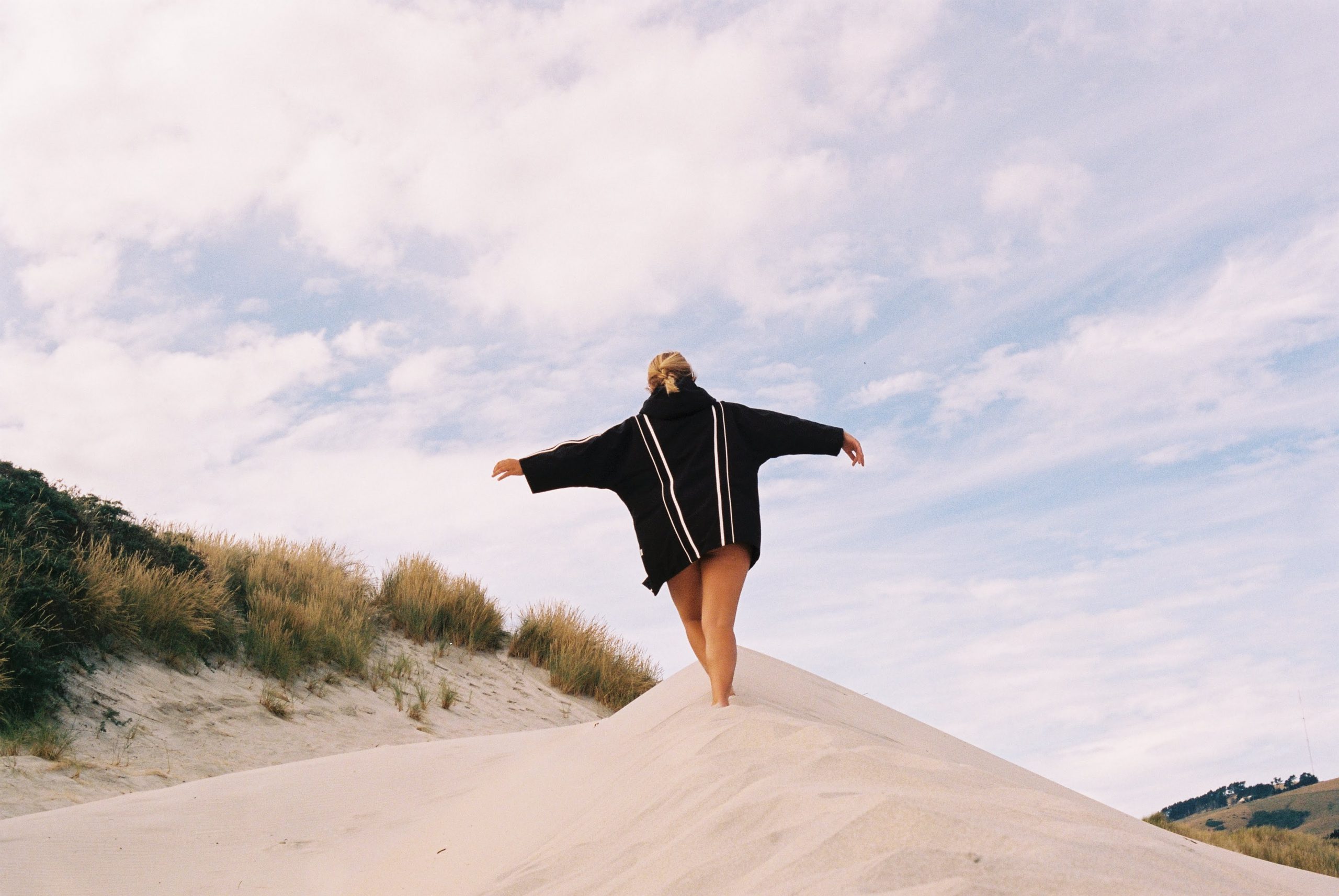 girl walking up the sand dune