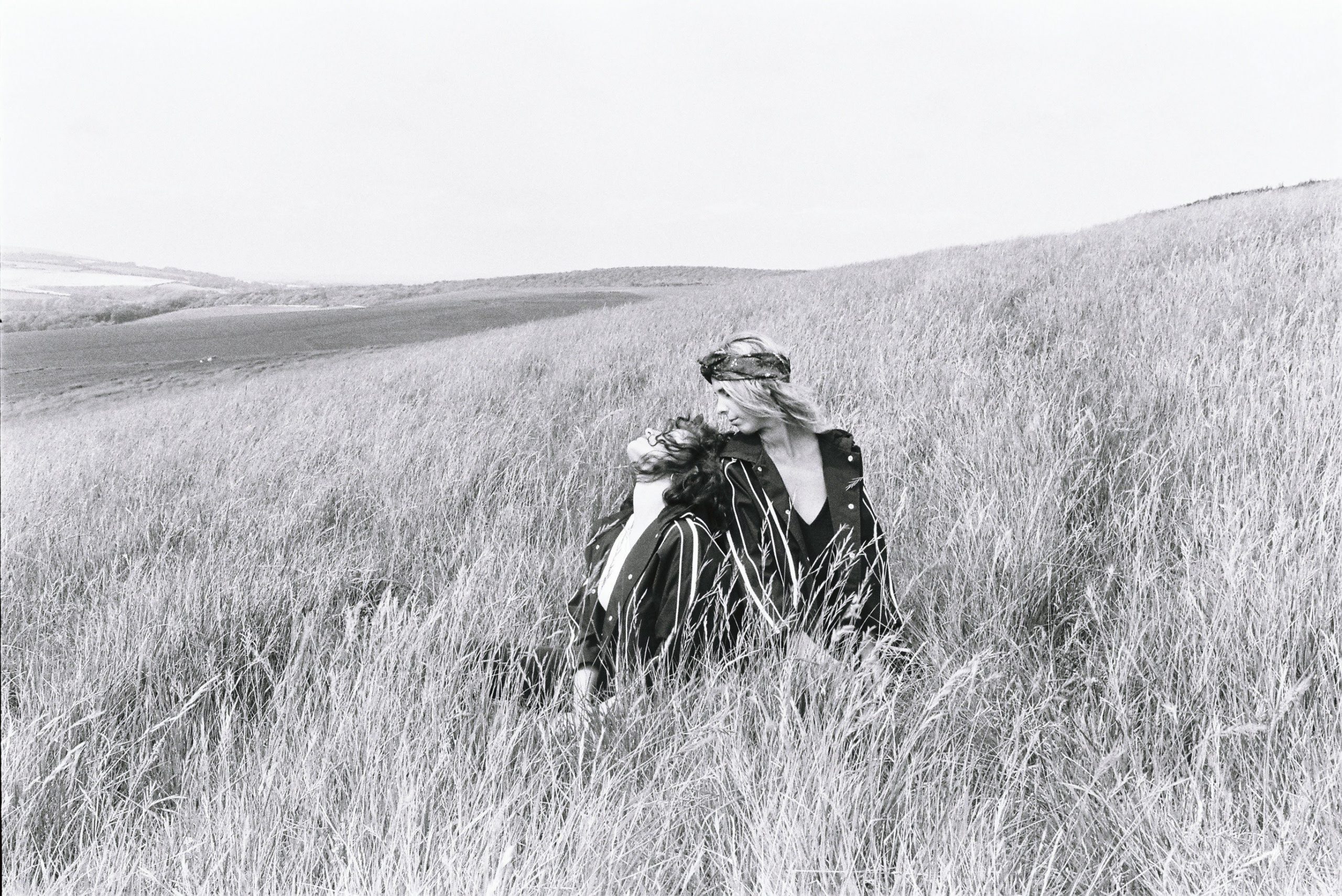 portrait of two women sitting in a weat field in black and white