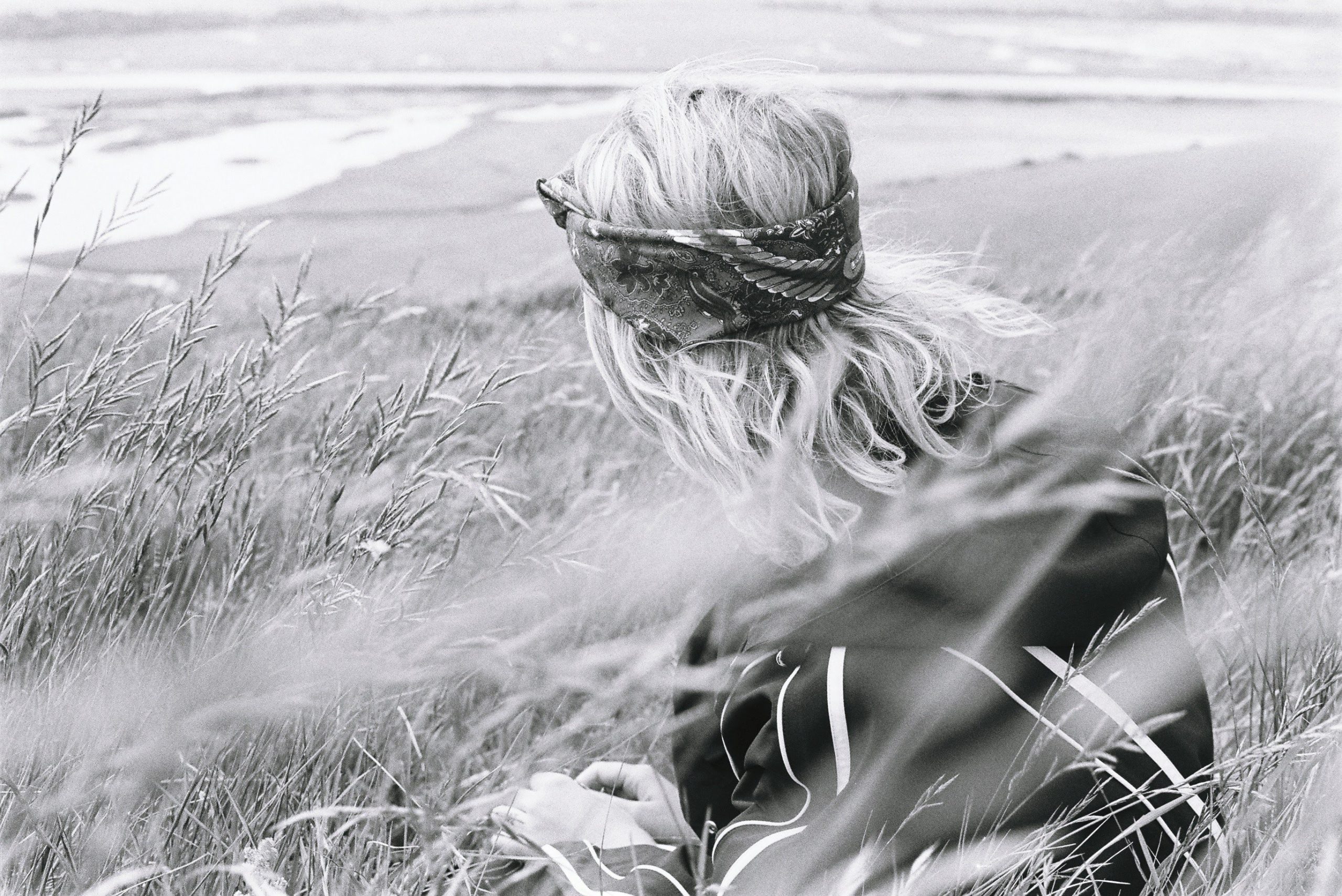 woman portrait sitting in a weat field in black and white