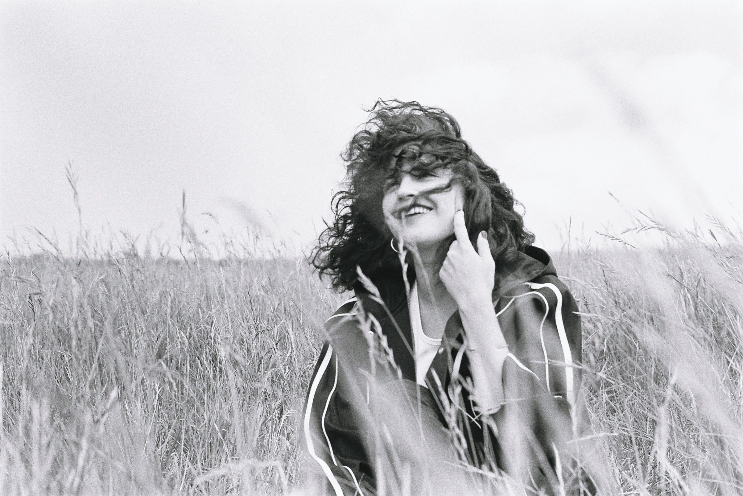 Smiling girl in weat field in black and white fashion